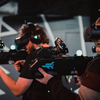Landscape image of two men engrossed in a VR shooting game